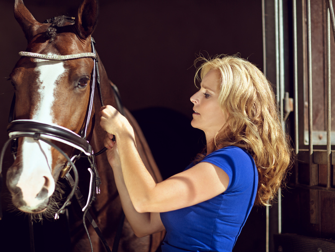 women checking her tack before riding